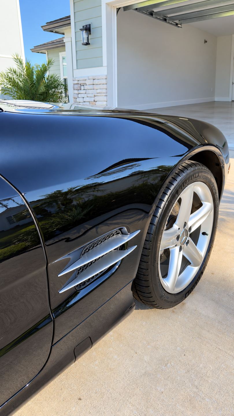 The same black fender after detailing, deep gloss with clean reflections